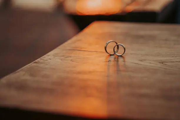 Wedding rings on a beautiful wooden texture surface closeup