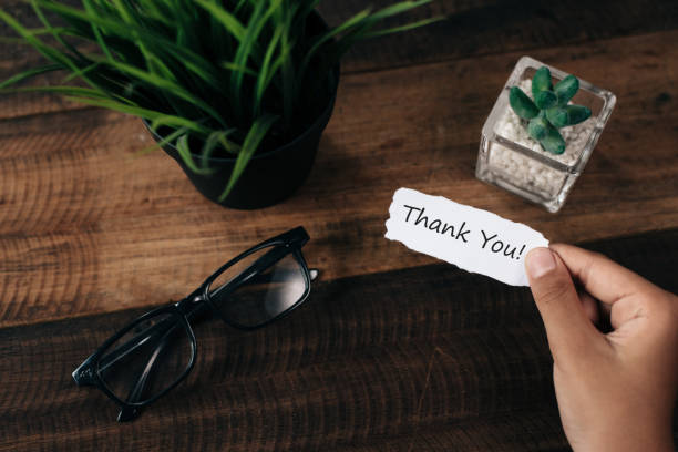 istock Cropped Hand Holding Thank You Card By Plants Over Table 1028344492