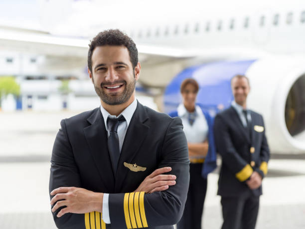 istock Happy pilot with his crew next to an airplane 1028360508
