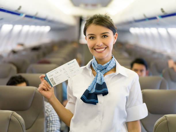 istock Flight attendant in an airplane holding a boarding pass 1028360718