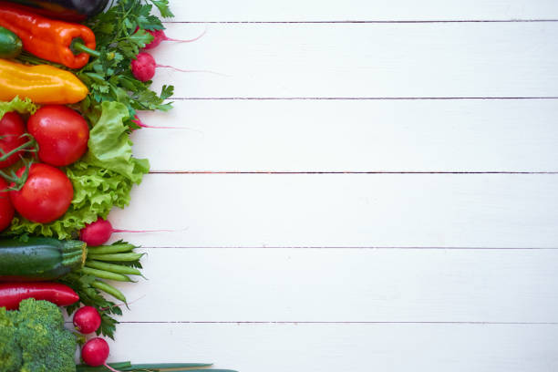 istock Fresh organic vegetables on white wooden boards background, top view. 1028363444