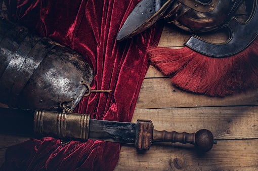 Complete combat equipment of the ancient Greek warrior on a wooden boards background.
