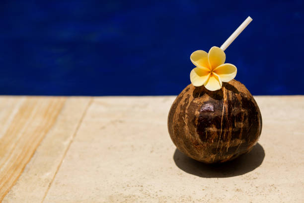 istock Coconut drink with yellow flower at poolside. 1028375532