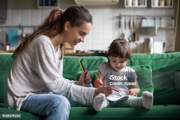 Mom And Kid Girl Drawing With Colored Pencils At Home Stock Photo - Download Image Now