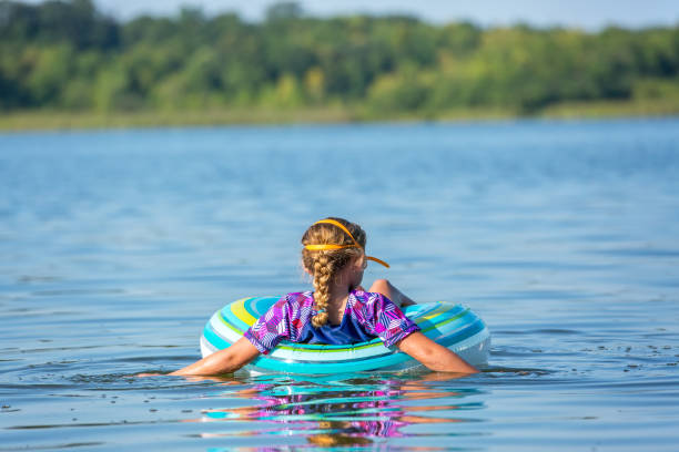 istock Girl Floating on Inner Tube Float Toy In Water 1028382620