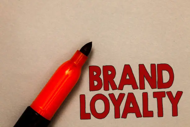 Photo of Word writing text Brand Loyalty. Business concept for Repeat Purchase Ambassador Patronage Favorite Trusted Open red marker intention communicating message ideas beige background
