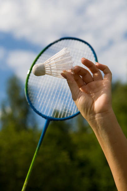 istock A female hand holds a shuttlecock against the sky. 1028394578