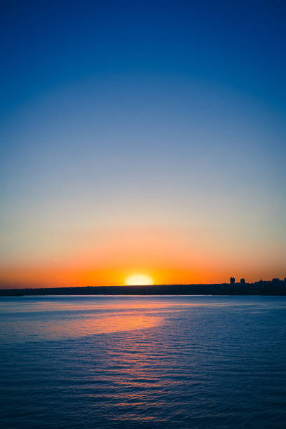 Sunset view from the Paranoa lake in Brasilia near by JK Bridge. In this photo: blue sky, orange and vivid sunset, blue lake without motion.