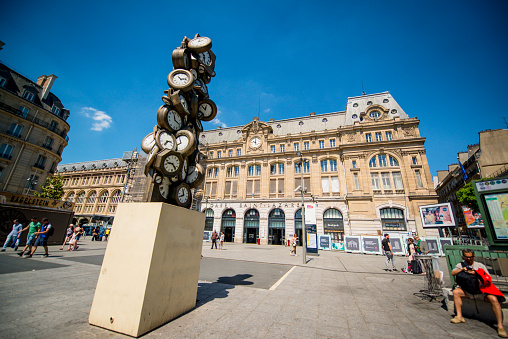 Paris, France - May 8, 2018: Gare St. Lazare exterior view with people outside and artwork by sculptor Arman. Gare Saint Lazare is one 6 largest train stations in Paris.