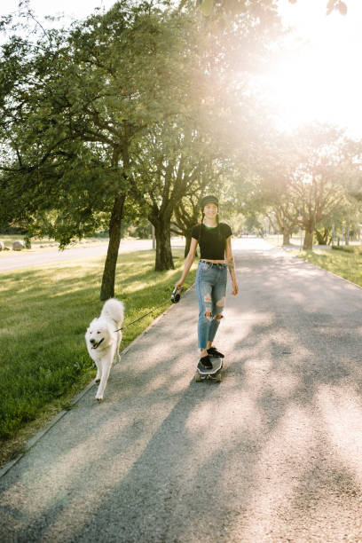 istock Woman longboarding with her dog 1028411094