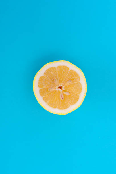 istock Cut across a ripe yellow lemon on a blue background 1028414658