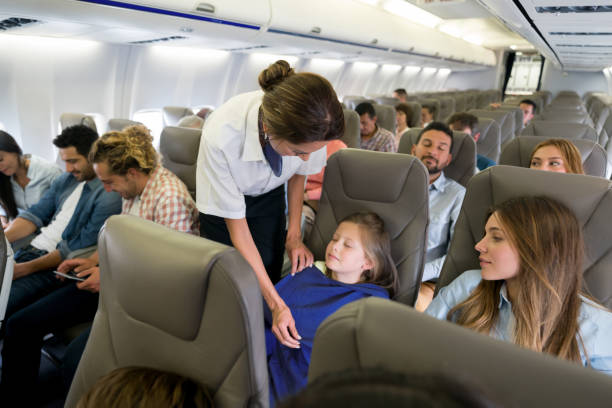 istock Flight attendant checking on a girl sleeping onboard 1028421432