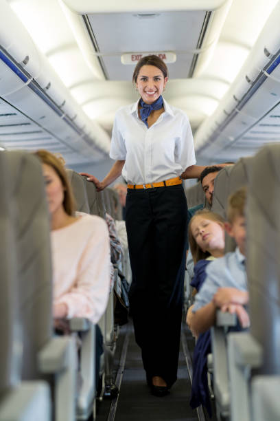istock Beautiful flight attendant walking the aisle in an airplane 1028421466