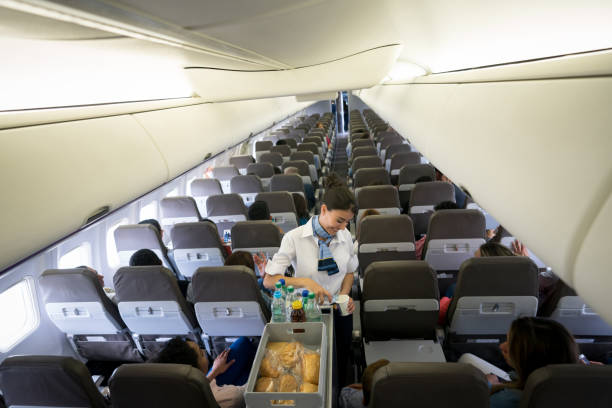 istock Happy flight attendant serving drinks in an airplane 1028421608