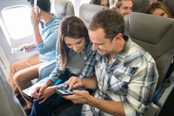 istock Couple traveling by plane and using their cell phone onboard 1028421722