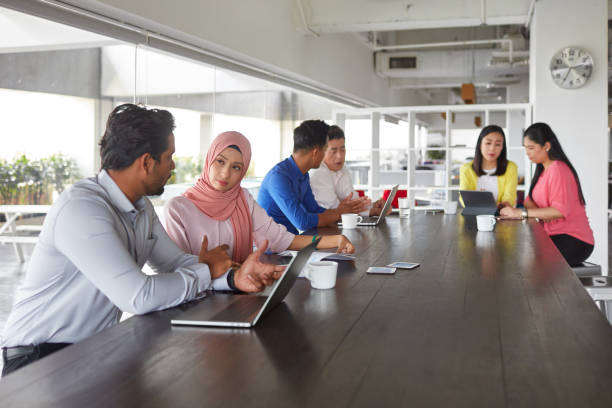istock Group of multi-ethnic business people sitting at a table and discussing work in modern office 1028421878