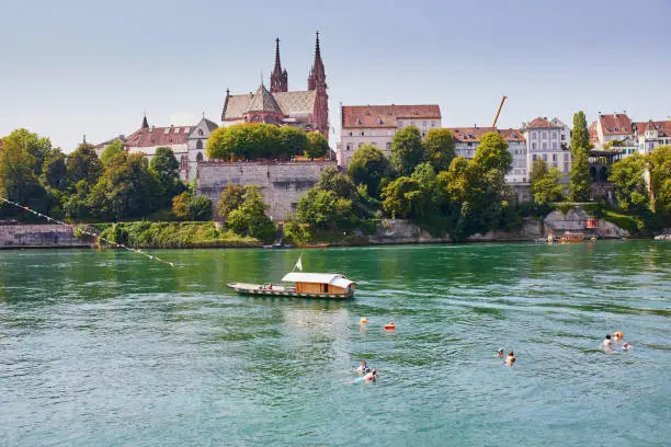 Scenic view of Rhine embankment with ferry boat crossing the river in Basel, Switzerland