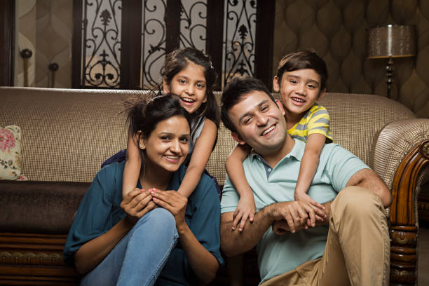 Smiling family on sofa - Stock image