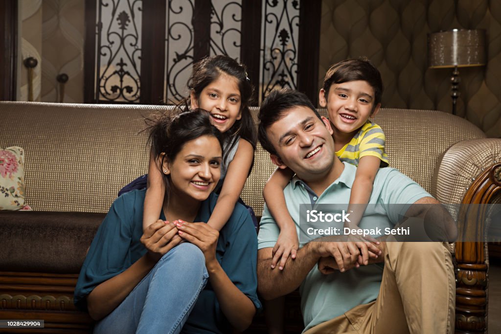 Família sorridente no sofá - imagem de estoque - Foto de stock de Família royalty-free