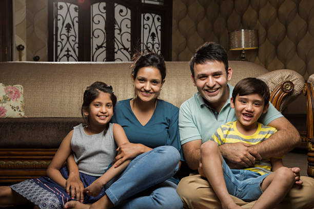istock Smiling family on sofa - Stock image 1028430170