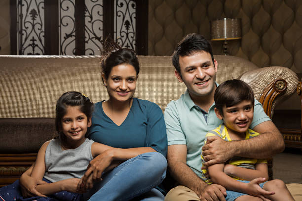 istock Smiling family on sofa - Stock image 1028430248