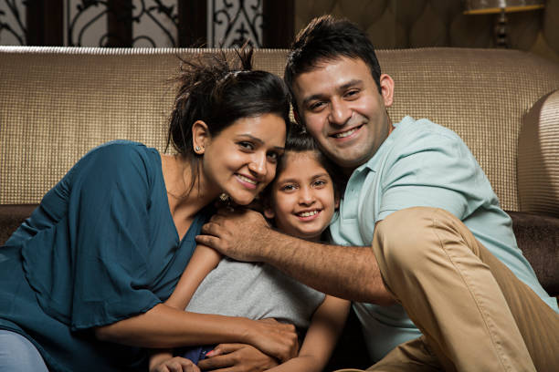 istock Smiling family on sofa - Stock image 1028435228