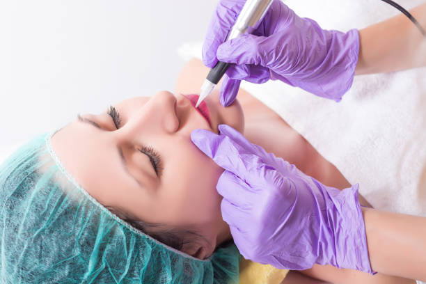 istock Professional permanent makeup applying on woman lips 1028435256