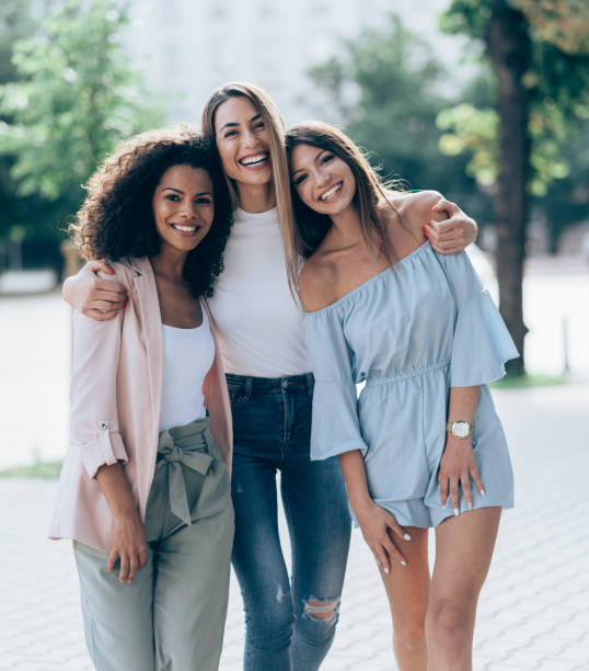 Three Girlfriends looking happy together Three Girlfriends looking happy together outdoors in sunny summer day cheek to cheek stock pictures, royalty-free photos & images
