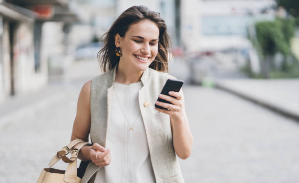 istock Young happy woman walking and texting 1028440516