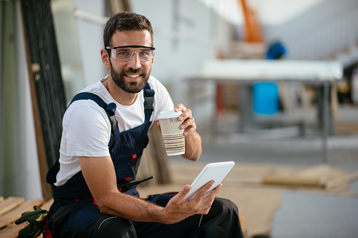 Factory worker having coffee break. Shadow DOF. Developed from RAW; retouched with special care and attention; Small amount of grain added for best final impression. 16 bit Adobe RGB color profile.