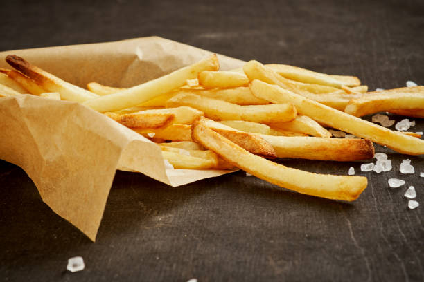 istock delicious and crispy fries in paper on a black old table 1028449880