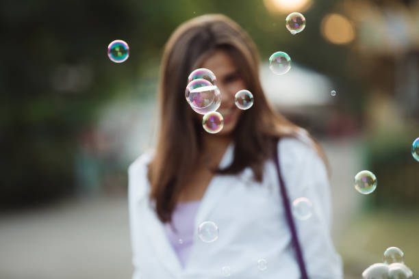 istock Happy adult girl blowing bubbles 1028457672