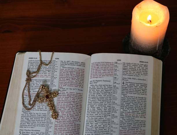 istock Burning candle open Bible with ornate gold gross 1028458354
