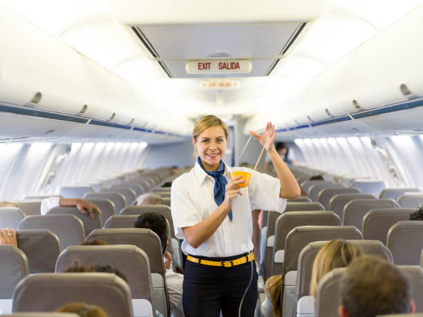 Flight attendant making an in-flight safety demonstration Portrait of a beautiful flight attendant making an in-flight safety demonstration and showing how to put the oxygen mask oxygen mask plane stock pictures, royalty-free photos & images