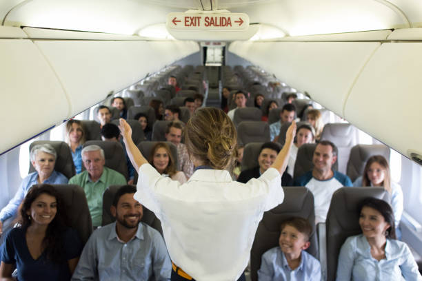 istock Flight attendant showing the emergency exit in an airplane 1028463148