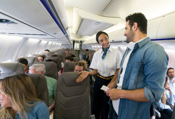 istock Air hostess helping man find his seat in an airplane 1028463230