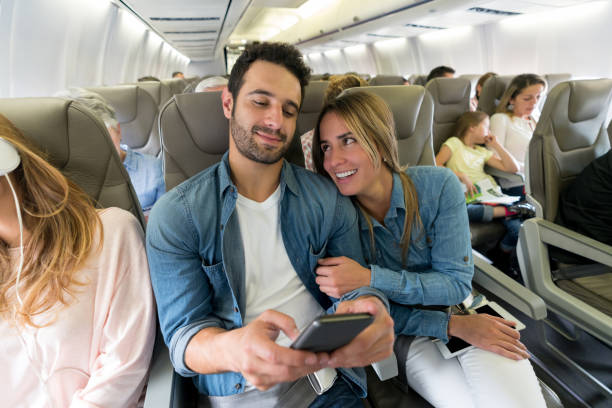 istock Loving couple traveling by plane and using their cell phone onboard 1028463258