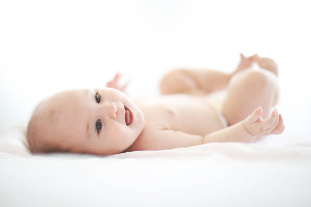 istock Cute baby on white bed 1028468766
