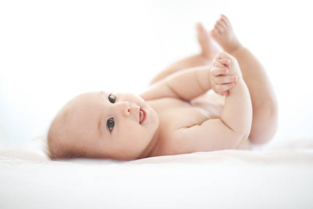 istock Cute baby on white bed 1028474600