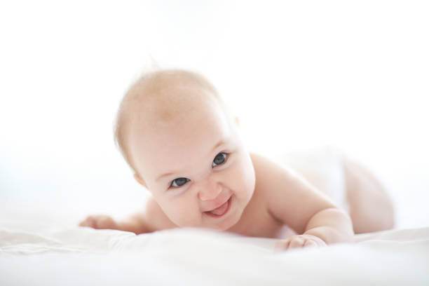 istock Cute baby on white bed 1028474738