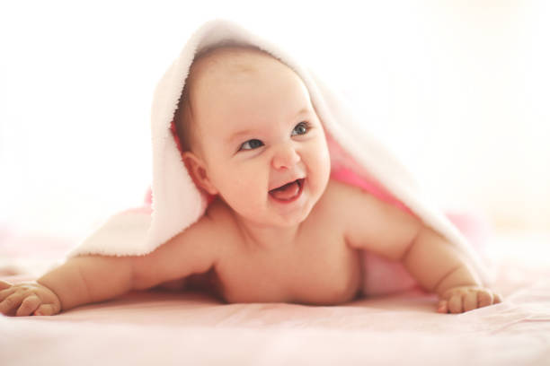 istock Cute baby on white bed 1028477638