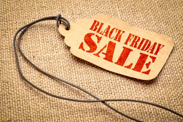 Black Friday sale sign - a paper price tag with a twine against burlap canvas