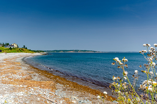 In this picturesque setting, the stone beach of Fårö comes alive serving as a vivid foreground that instantly grabs attention. This is set against an expansive seascape that stretches as far as the eye can see, offering a sense of endlessness and tranquility. The contrasting hues of the colorful stones and the deep blues and greens of the ocean create a visually arresting landscape that encapsulates the serene yet invigorating atmosphere of this coastal region.