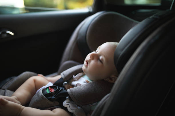 ребенок спит в сиденье безопасности автомобиля в то время как - car baby baby car seat child стоковые фото и изображения