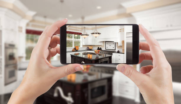 vrouwelijke handen met slimme telefoon weergeven foto van keuken achter. - keuken huis fotos stockfoto's en -beelden