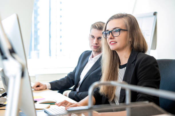 istock Businesswoman working on computer at the office with coworker 1028504914