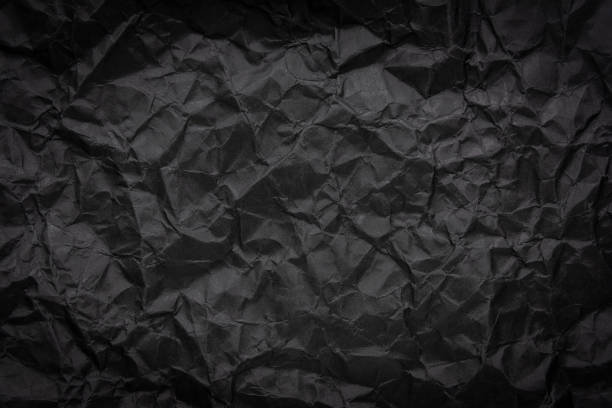 istock Ragged crumpled dark black paper texture background 1028504930