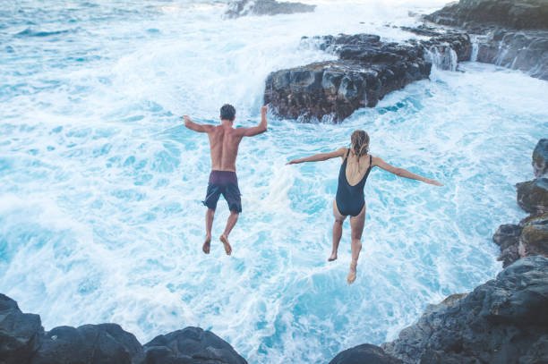 istock A millennial-age couple leaping into the ocean 1028512656