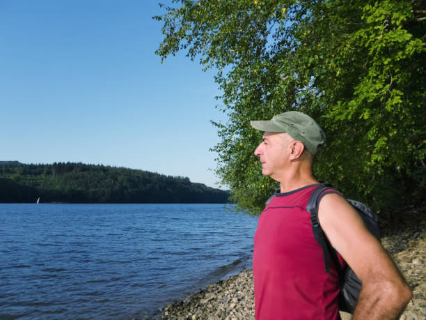 istock A traveler with a backpack is standing by the lake. 1028515818