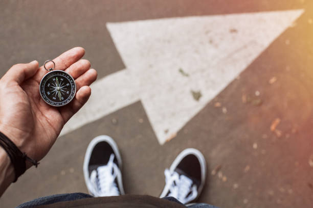 Traveler holding compass in the hand making choice stock photo